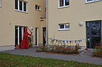 Kita - entrance (house 1). In front of it is a red sculpture of the Nordhausen Roland. At the house hangs a colorful pennant chain