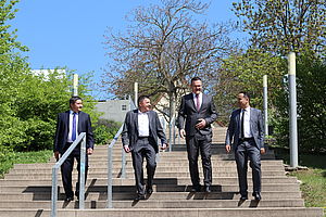 4 Männer laufen eine Treppe herunter
