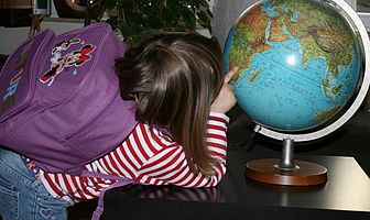 A child looks at a globe