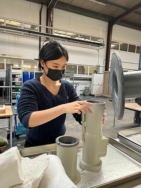 Engagierte Mitarbeiterin bei der Qualitätskontrolle: Yuwei Chang überprüft ein technisches Bauelement im Rahmen ihrer Arbeit an innovativen Umwelttechnologie-Projekten.