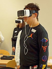 Die Abbildung zeigt eineinen Schüler mit einer Virtual Reality-Brille.