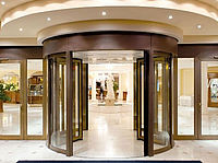 Hotel entrance - glass revolving door with small lamps on the ceiling