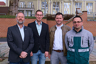 Professor Folker Flüggen, Maschinenbau-Absolvent Nico Stang und Marco Buchmann sowie Andreas Benkstein von der DEKRA vor dem Hintergrund des Audimax