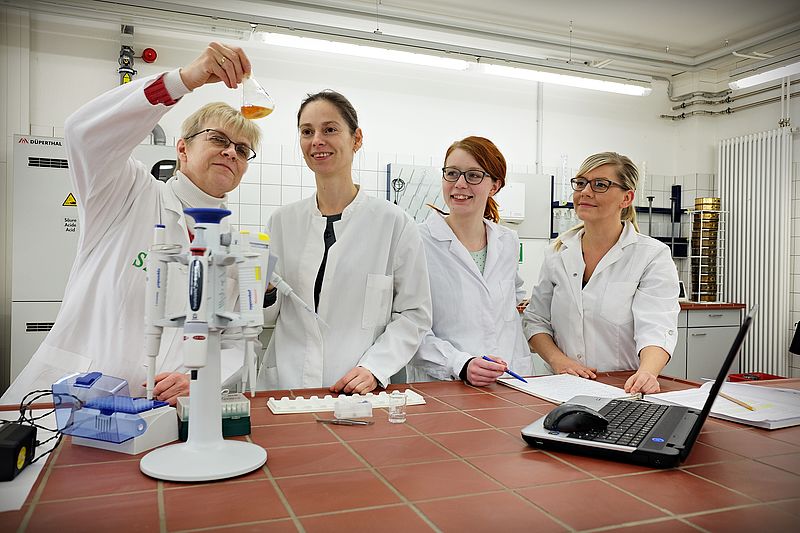 Four female scientists work on a biogas research project in a laboratory at Nordhausen University of Applied Sciences and analyse a liquid sample using laboratory equipment.