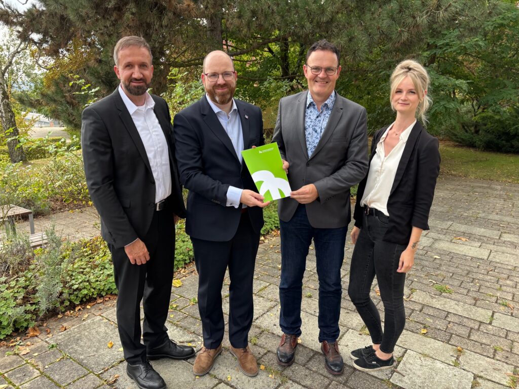 Gruppenfoto mit Präsentation eines Dokuments.