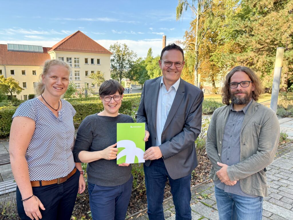 Gruppe präsentiert ein Dokument im Freien.