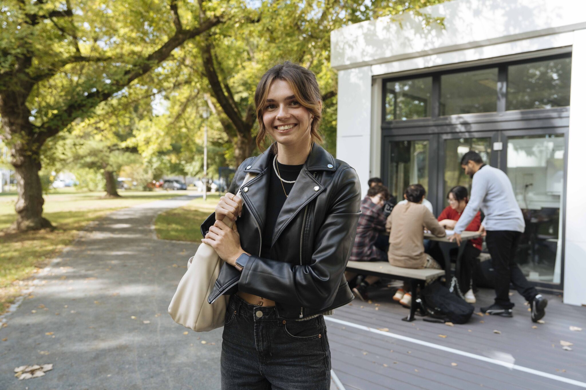 Young woman with leather jacket in the park