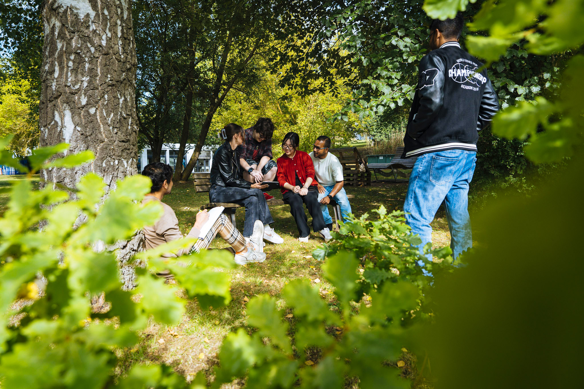Gruppe von Studierenden auf dem grünen Campus
