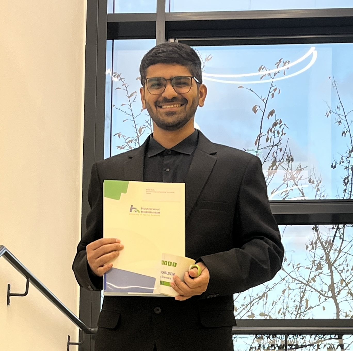 Young man with documents and cup.