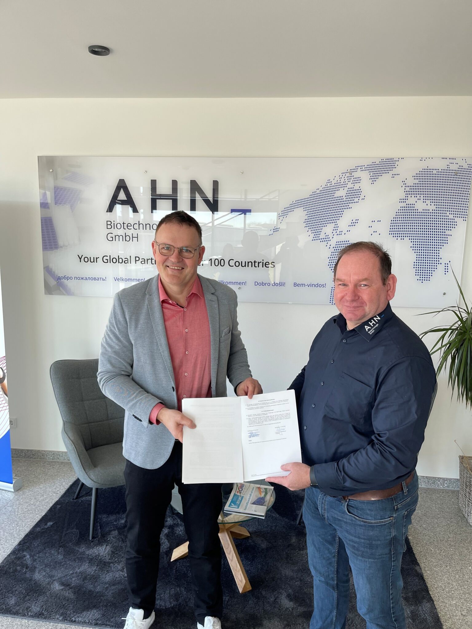 Zwei Männer unterzeichnen ein Dokument.