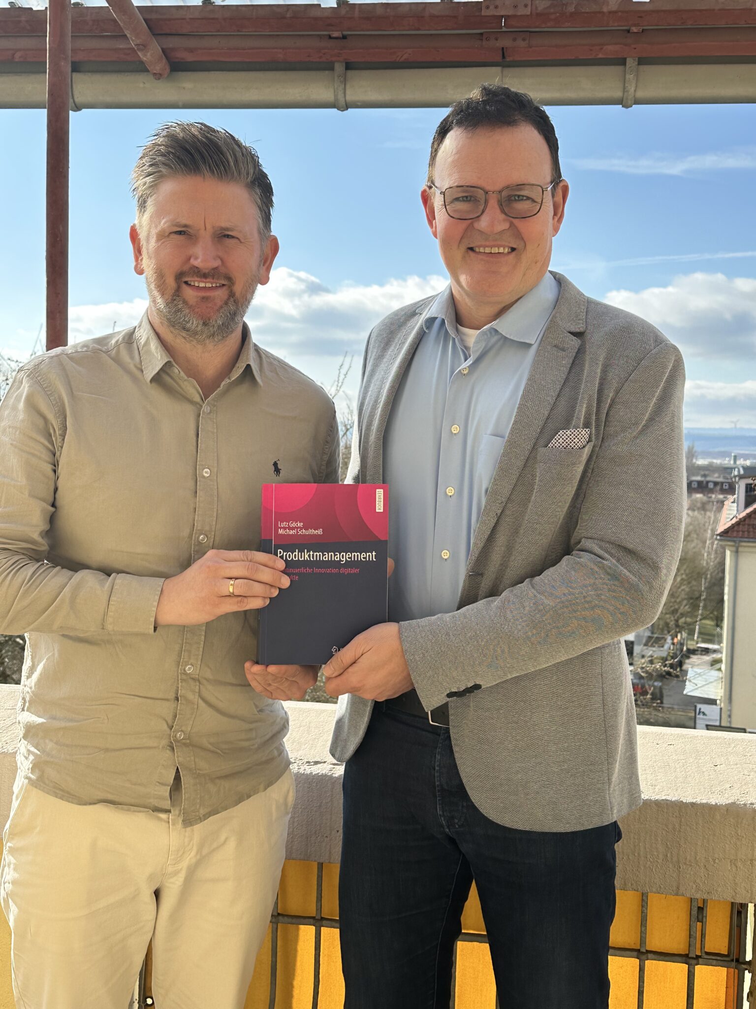 Zwei Männer mit Buch im Freien