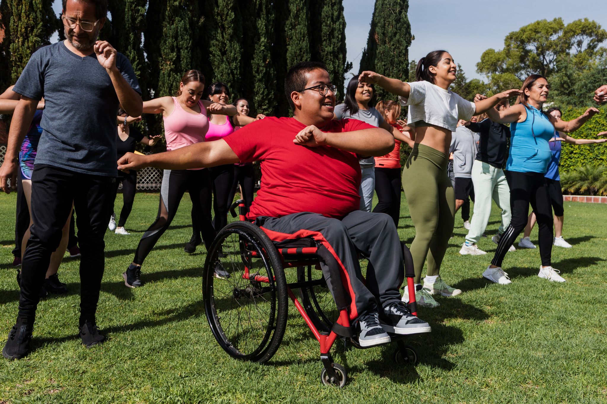 Group dance with wheelchair users outdoors