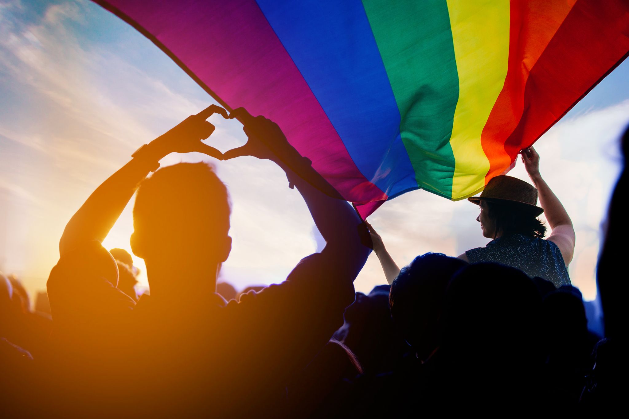 People celebrate with the rainbow flag