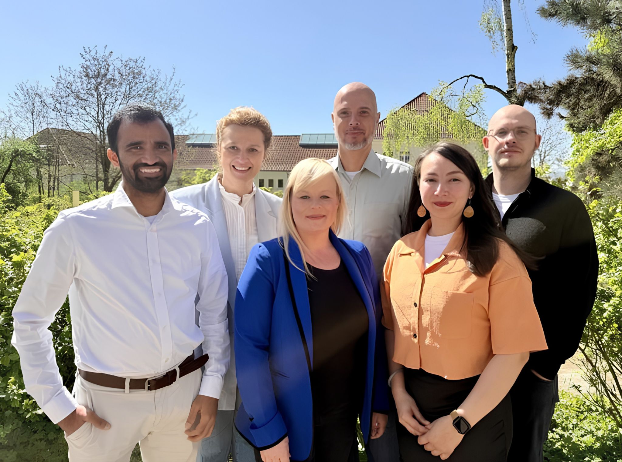 Sechs Personen vor grünem Hintergrund.