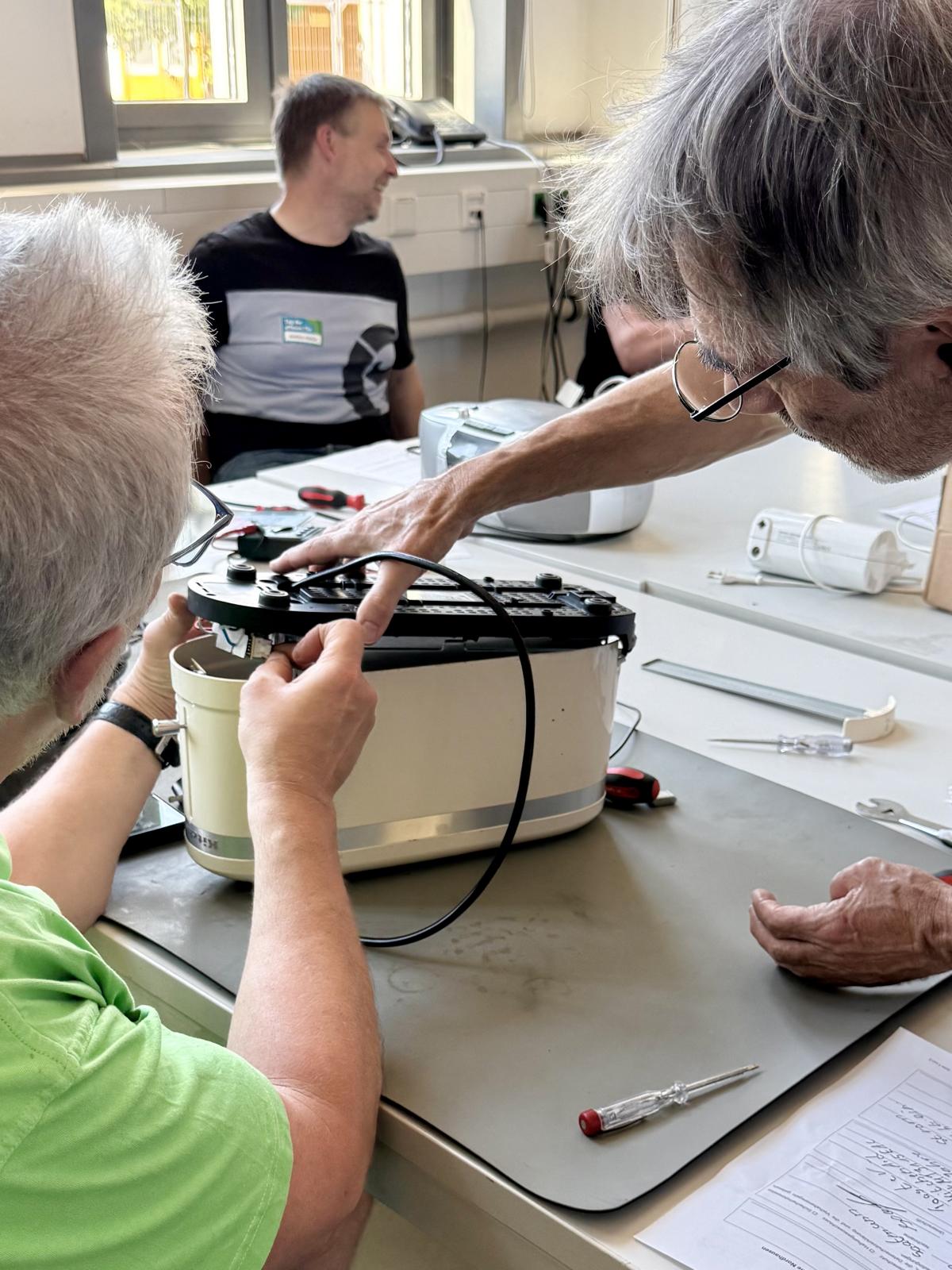 Menschen arbeiten an einem Gerät.