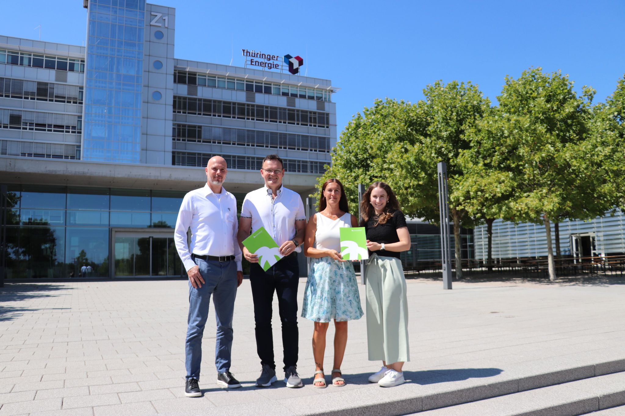 Four people in front of a modern building.