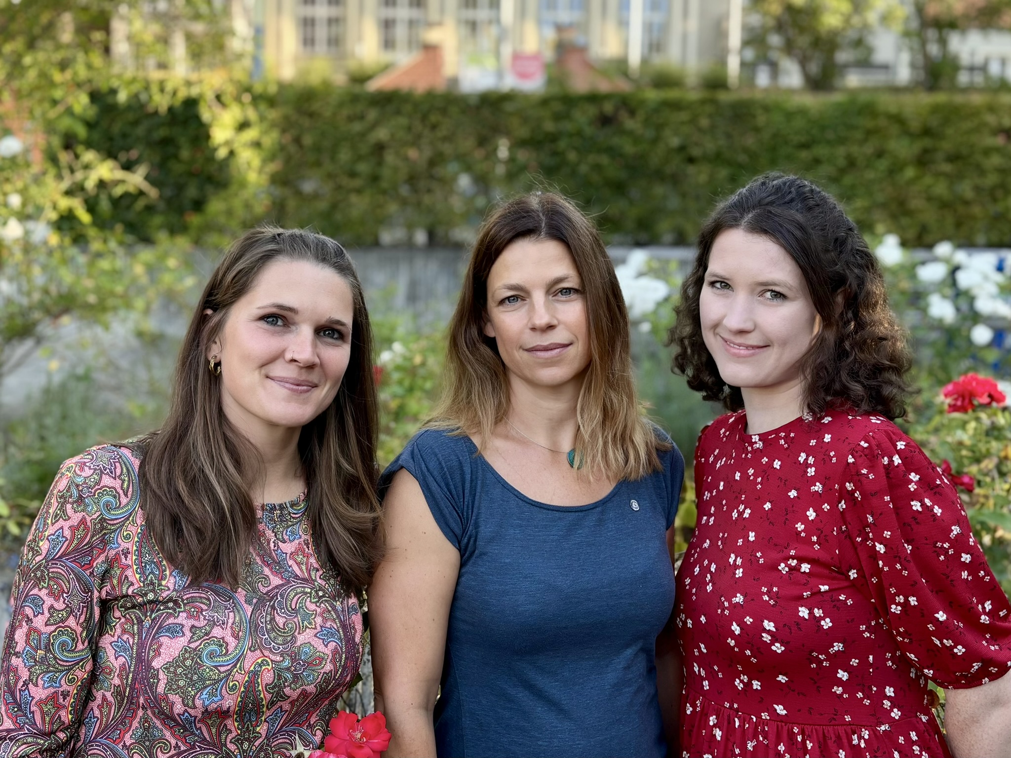Drei Frauen vor Blumen im Garten